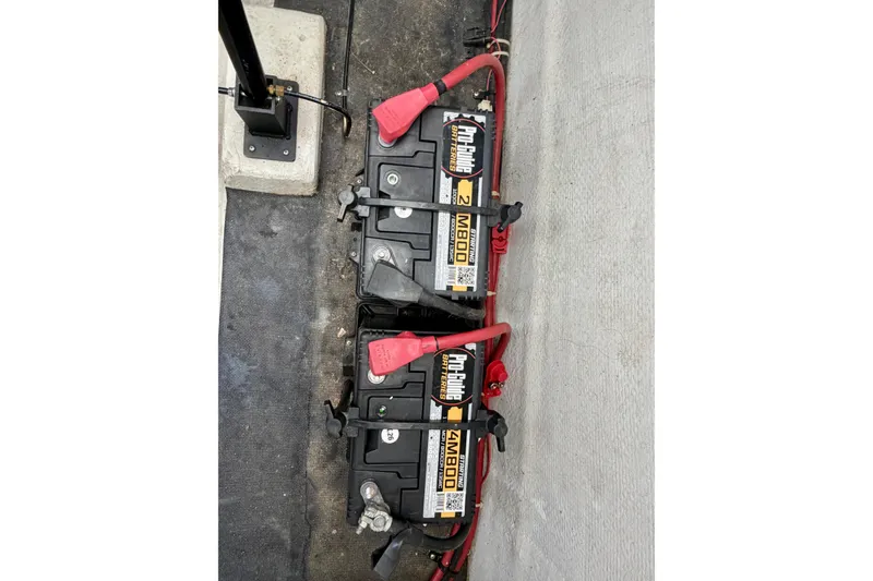 Slide: The Image of Dual marine batteries with red cables in a 2003 Cobalt 282 boat. - 24