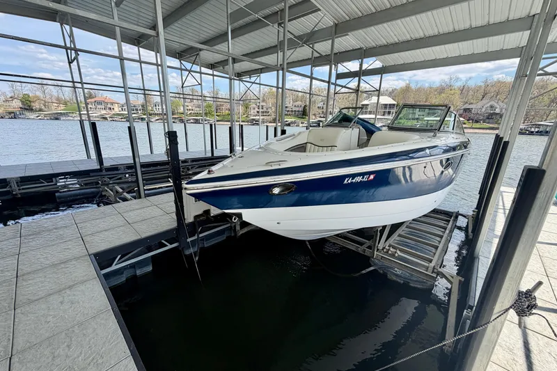 Slide: The Image of 2003 Cobalt 282 boat docked in a covered marina with scenic lake view. - 3