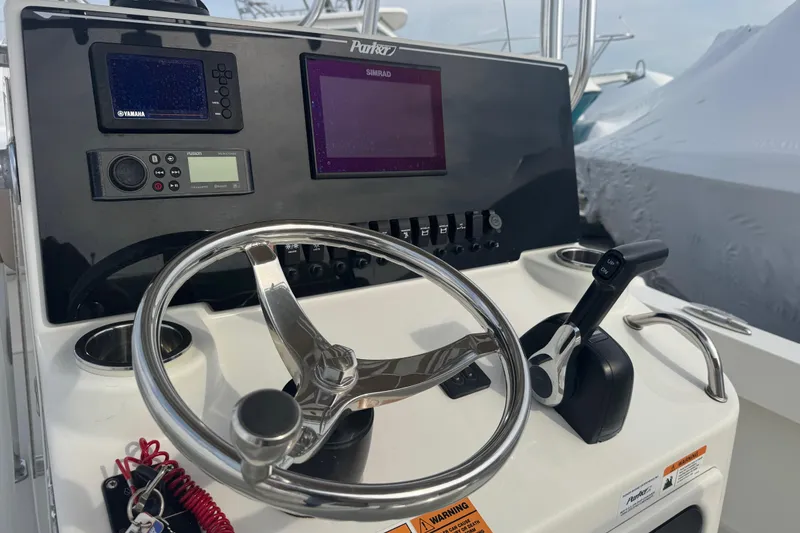 Slide: The Image of Control panel of a 2019 Parker 23 Special Edition boat with steering wheel and navigation equipment. - 3