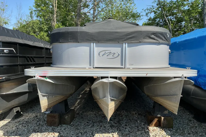 The Image of 2018 Manitou 23 Aurora LE RF pontoon boat on gravel, covered and stored outdoors. - 1