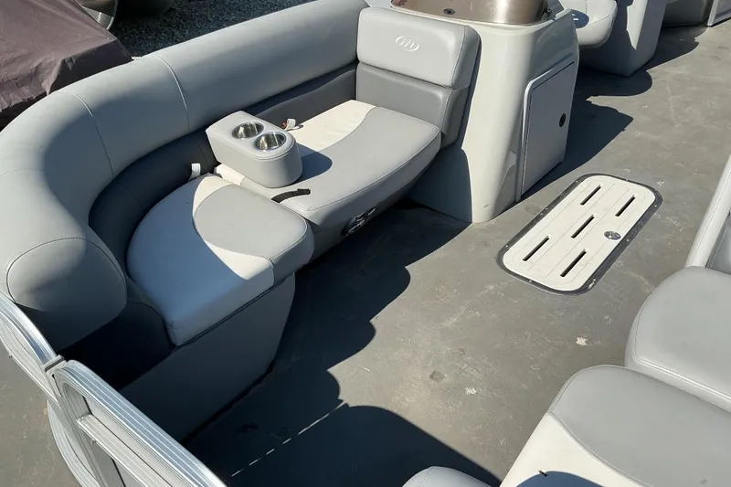 Slide: The Image of 2018 Manitou 23 Aurora LE RF boat interior with gray seating and cup holders. - 13