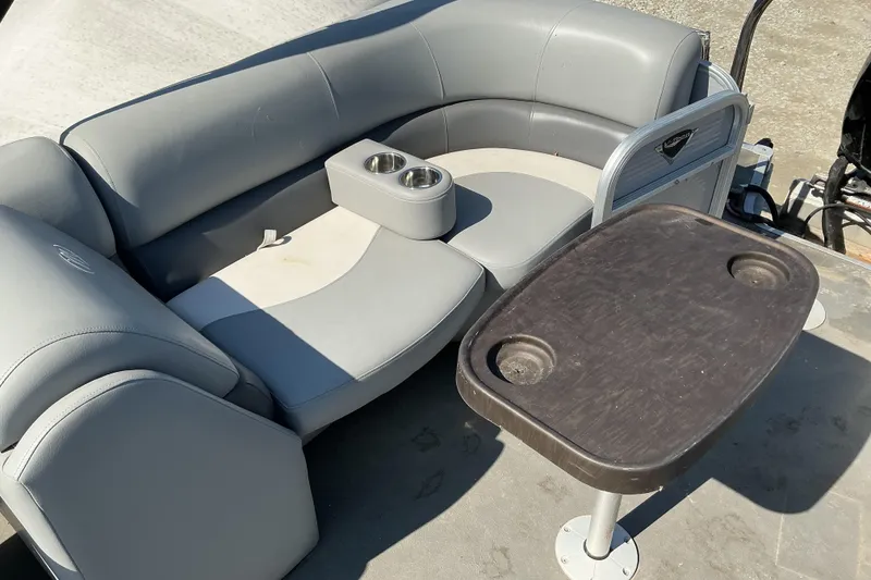 Slide: The Image of 2018 Manitou 23 Aurora LE RF boat interior with gray seating and table. - 15