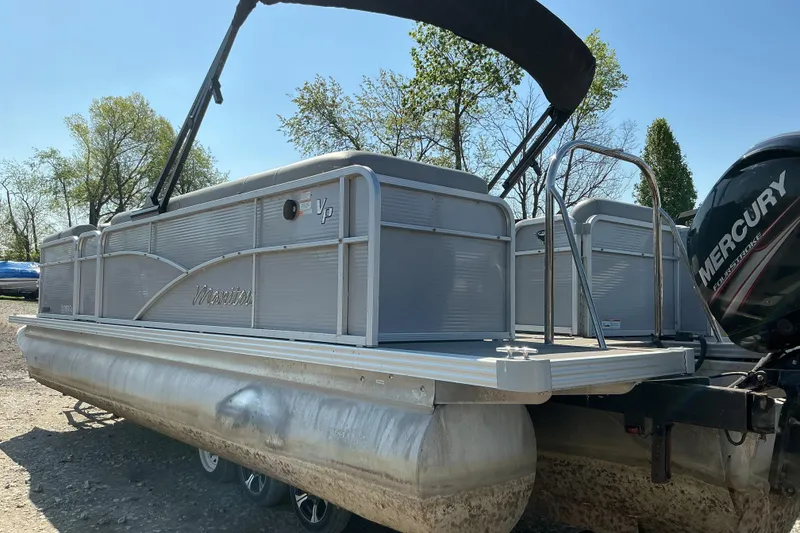 Slide: The Image of 2018 Manitou 23 Aurora LE RF pontoon boat with Mercury engine, parked outdoors. - 8