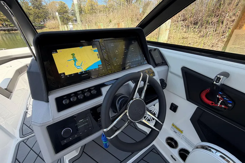 Slide: The Image of 2026 Cobalt R6 Outboard boat interior with logo, docked near trees and water. - 27