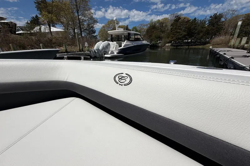 Slide: The Image of 2026 Cobalt R6 Outboard boat interior with open storage compartment, docked near other boats. - 31