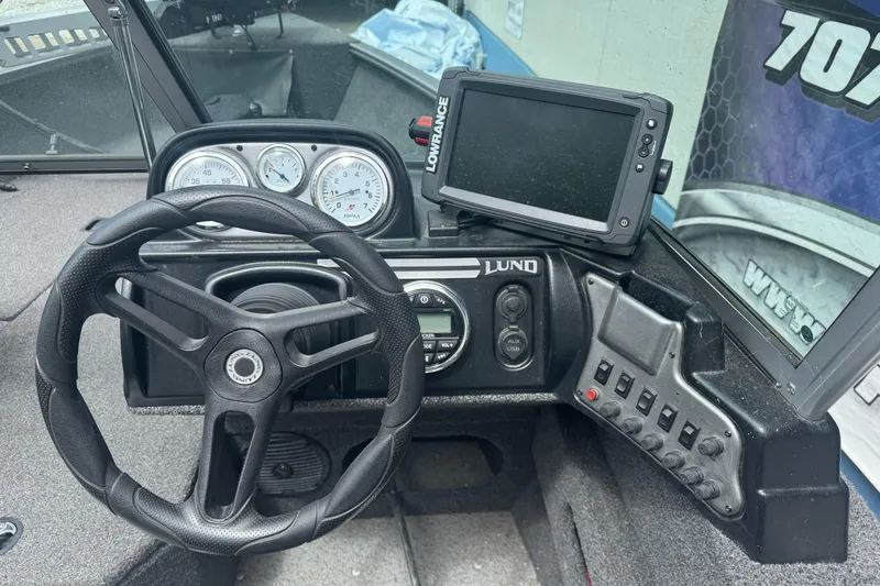 Slide: The Image of Dashboard of a 2019 Lund 1675 Adventure Sport boat with steering wheel and gauges. - 13