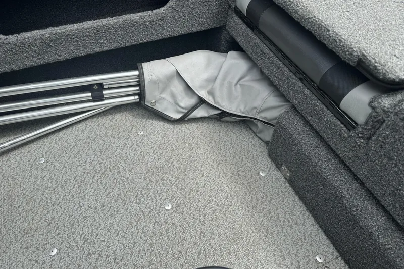 Slide: The Image of Interior of 2019 Lund 1675 Adventure Sport boat with folded metal poles and gray carpet. - 18