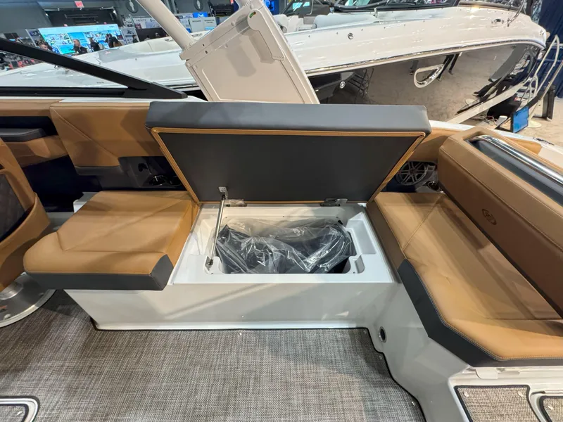 Slide: The Image of 2025 Cobalt R8 Outboard boat interior with open storage compartment and tan seating. - 10