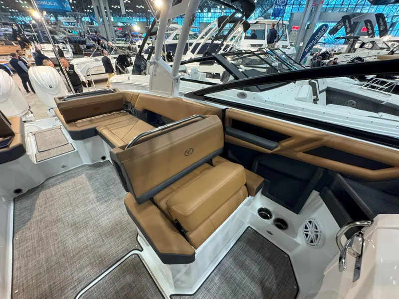 Slide: The Image of 2025 Cobalt R8 Outboard interior with tan seating at a boat show. - 12