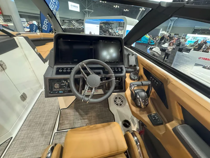 Slide: The Image of 2025 Cobalt R8 Outboard cockpit with modern steering and controls at a boat show. - 17