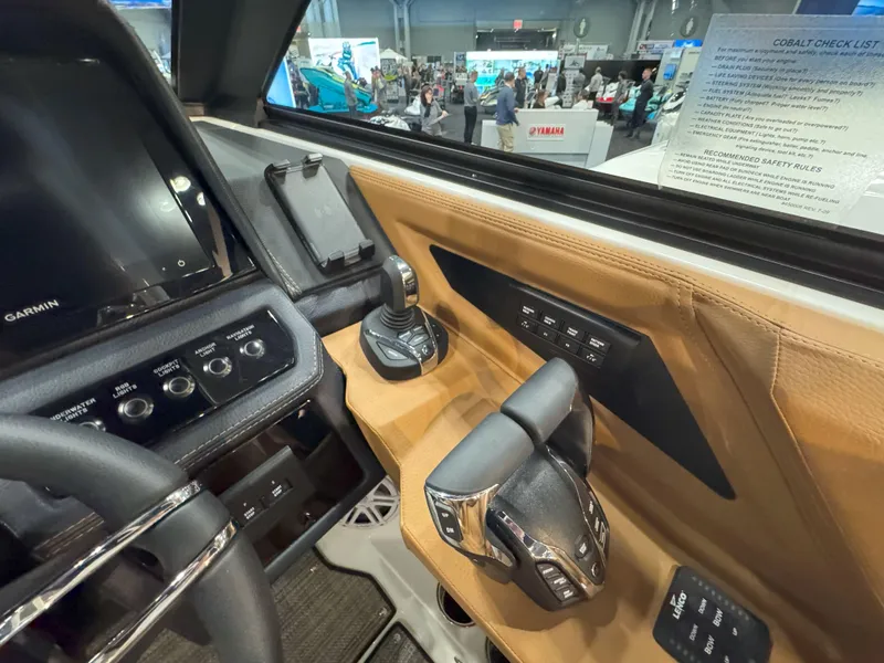 Slide: The Image of 2025 Cobalt R8 Outboard cockpit with advanced controls and display at a boat show. - 18
