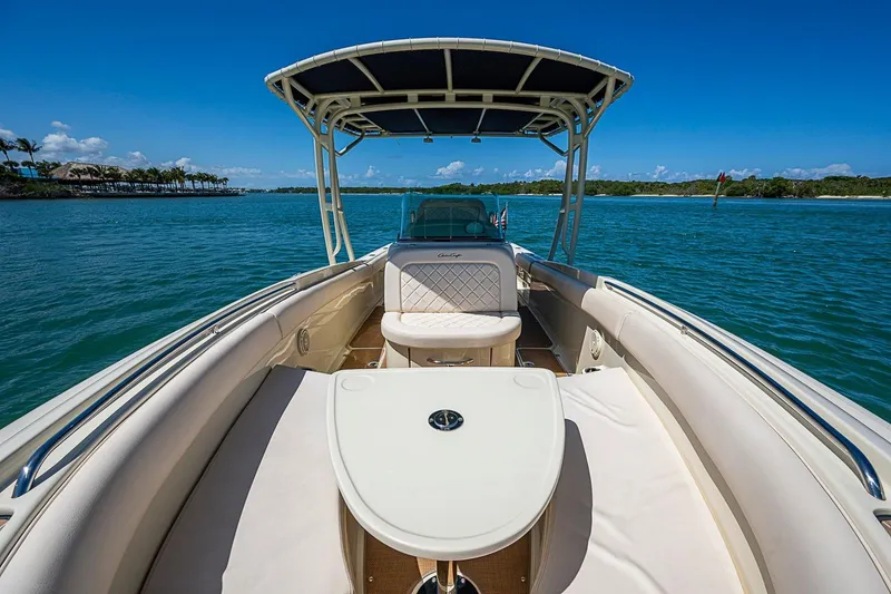 Slide: The Image of 2017 Chris-Craft Catalina 26 boat on serene blue water, featuring spacious seating and canopy. - 11