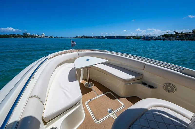 Slide: The Image of 2017 Chris-Craft Catalina 26 boat interior with seating and table on calm water. - 14