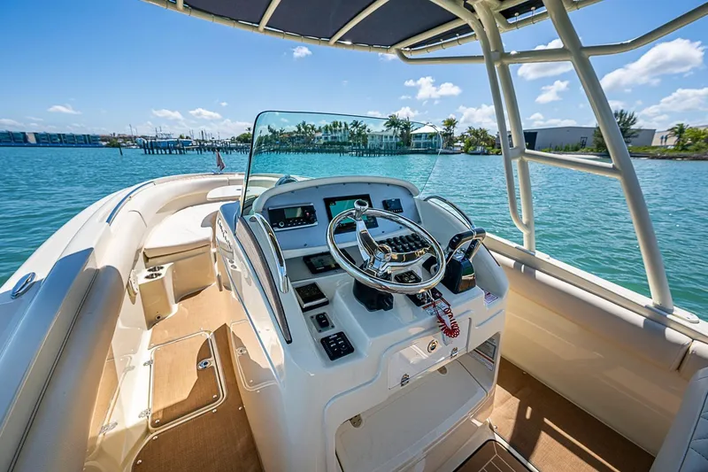 Slide: The Image of 2017 Chris-Craft Catalina 26 boat interior with steering wheel, on a sunny day by the water. - 6