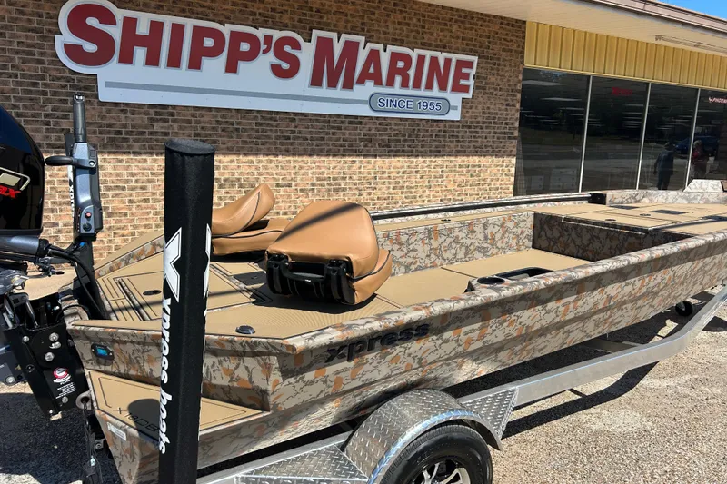Slide: The Image of 2026 Xpress X18DB boat with camouflage design at Shipp's Marine dealership. - 11