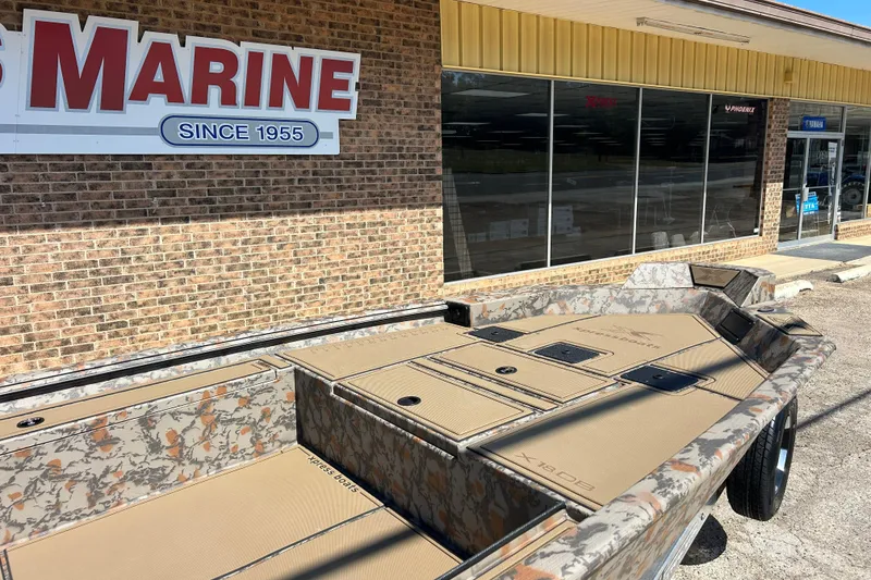 Slide: The Image of 2026 Xpress X18DB boat with camouflage design outside a marine store. - 3