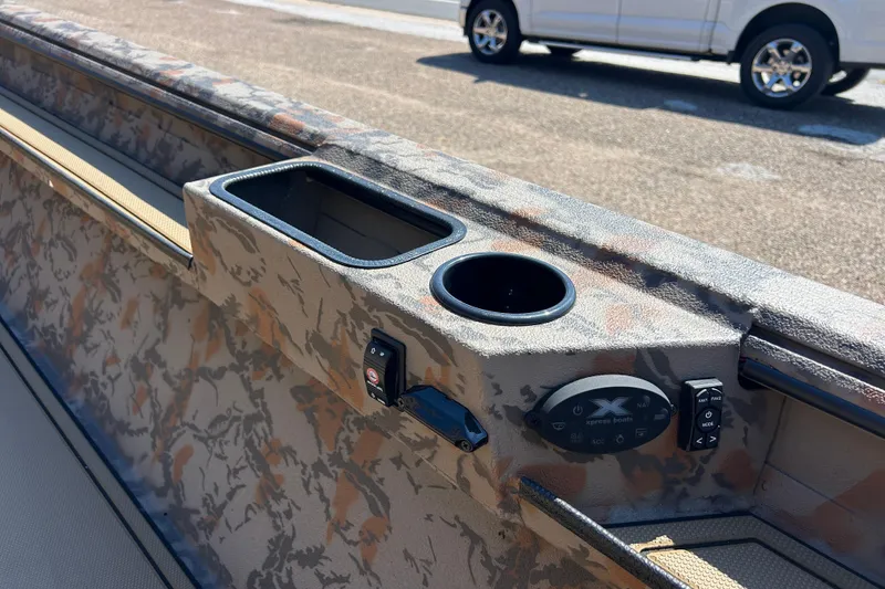 Slide: The Image of Camouflage interior of 2026 Xpress X18DB boat with cup holder and control panel. - 6