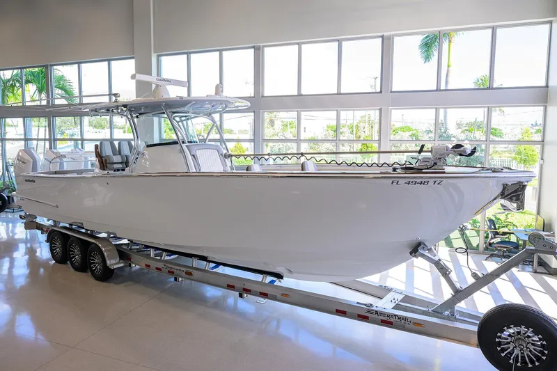 Slide: The Image of 2025 Valhalla Boatworks V-37 on trailer in showroom, sleek design, large windows. - 2