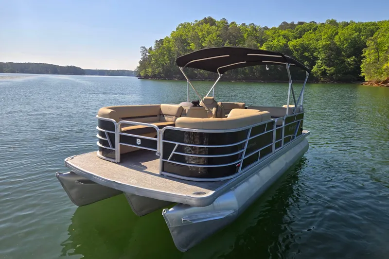 The Image of 2023 Godfrey Sweetwater 2286 C pontoon boat on a serene lake. - 1