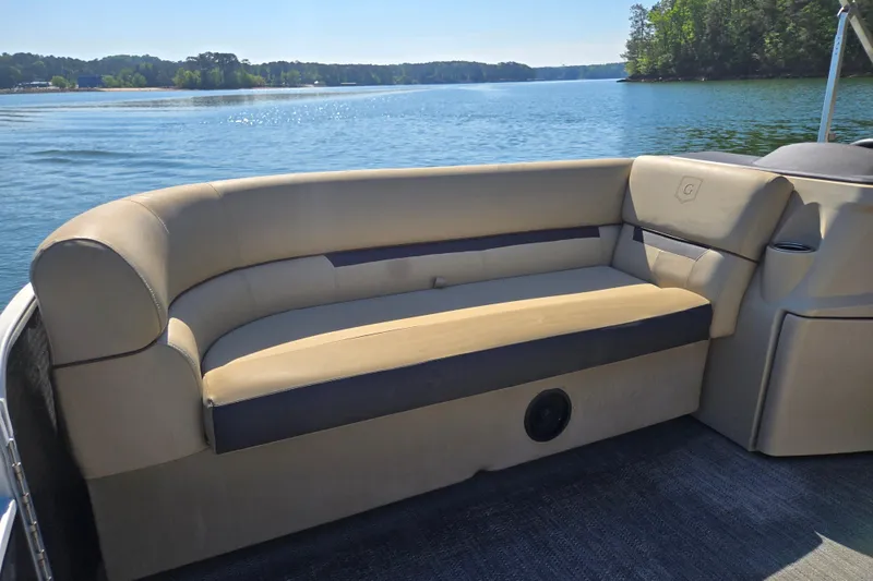 Slide: The Image of 2023 Godfrey Sweetwater 2286 C pontoon boat interior with beige seating on a serene lake. - 12