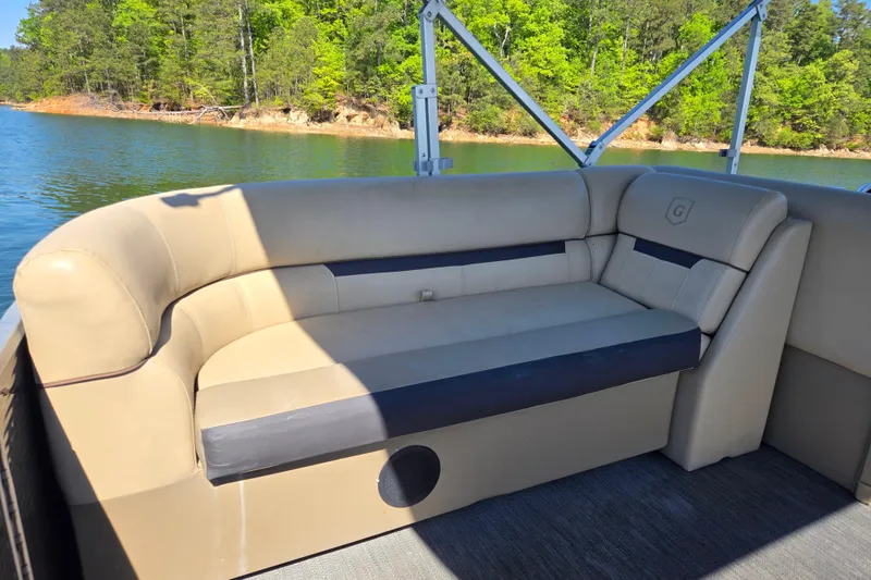 Slide: The Image of 2023 Godfrey Sweetwater 2286 C pontoon boat with beige seating, on a scenic lake. - 16