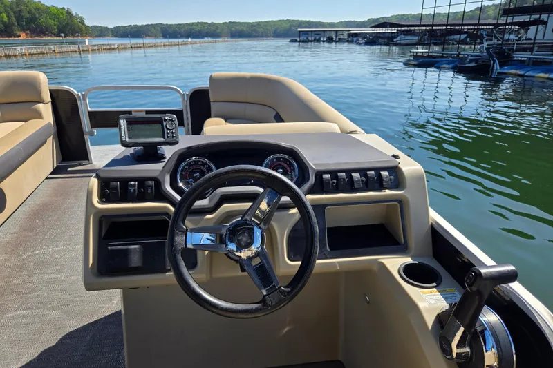 Slide: The Image of 2023 Godfrey Sweetwater 2286 C pontoon boat dashboard with steering wheel and controls on a lake. - 20