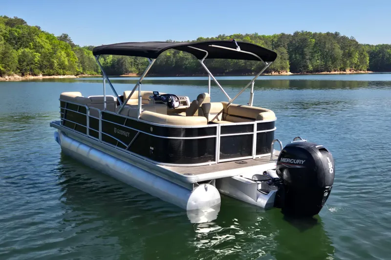 Slide: The Image of 2023 Godfrey Sweetwater 2286 C pontoon boat on a serene lake. - 7