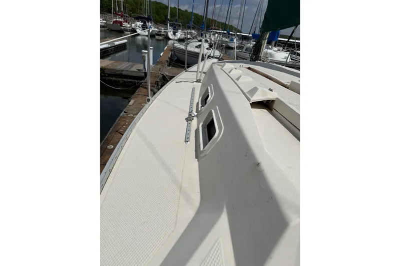 Slide: The Image of 1985 Hunter 25.5 sailboat docked at marina, showcasing deck and cabin details. - 4