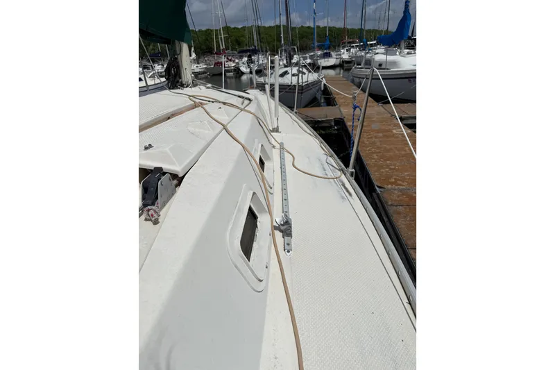 Slide: The Image of 1985 Hunter 25.5 sailboat docked at marina, showing deck and rigging. - 6