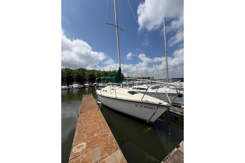Slide: The Image of 1985 Hunter 25.5 sailboat docked at marina under blue sky. - 8
