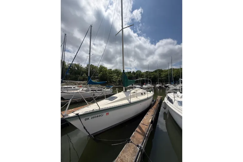 Slide: The Image of 1985 Hunter 25.5 sailboat docked at a marina under cloudy skies. - 9