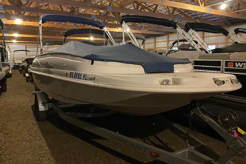 The Image of 2006 Starcraft 2000 IO Limited boat in storage, covered and on a trailer. - 0