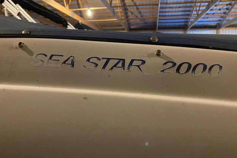 Slide: The Image of 2006 Starcraft 2000 IO Limited boat with "Sea Star 2000" decal in a warehouse. - 3