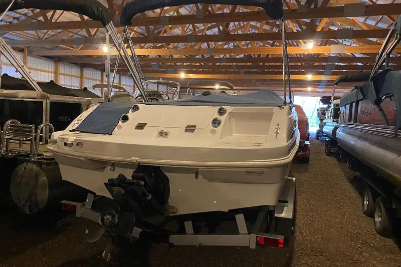 Slide: The Image of 2006 Starcraft 2000 IO Limited boat stored indoors, surrounded by other vessels. - 5