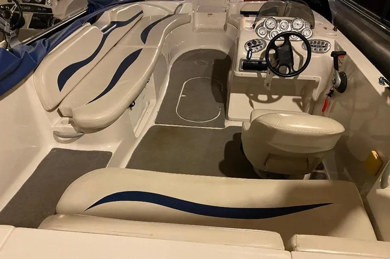 Slide: The Image of 2006 Starcraft 2000 IO Limited boat interior with beige seating and steering console. - 7