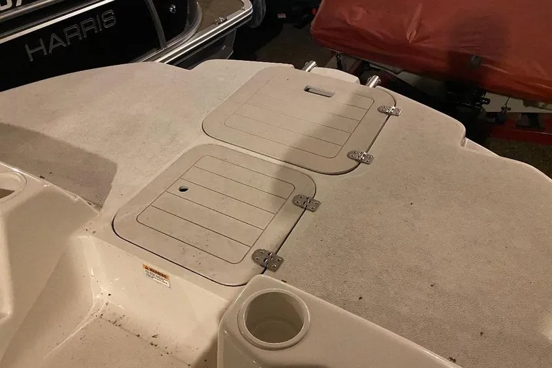 Slide: The Image of 2006 Starcraft 2000 IO Limited boat deck with storage compartments and cup holder. - 9