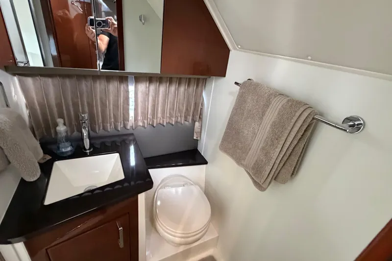 Slide: The Image of 2019 Carver C34 yacht bathroom with sink, toilet, and towel rack. - 13