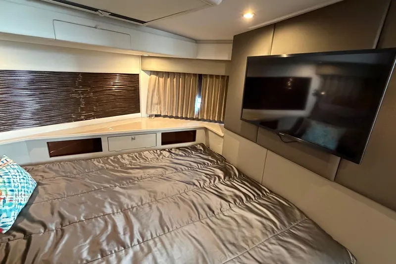 Slide: The Image of Luxurious 2019 Carver C34 yacht bedroom with TV, modern decor, and comfortable bedding. - 15