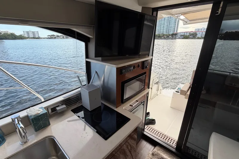 Slide: The Image of Interior of 2019 Carver C34 yacht with kitchen, TV, and water view. - 16