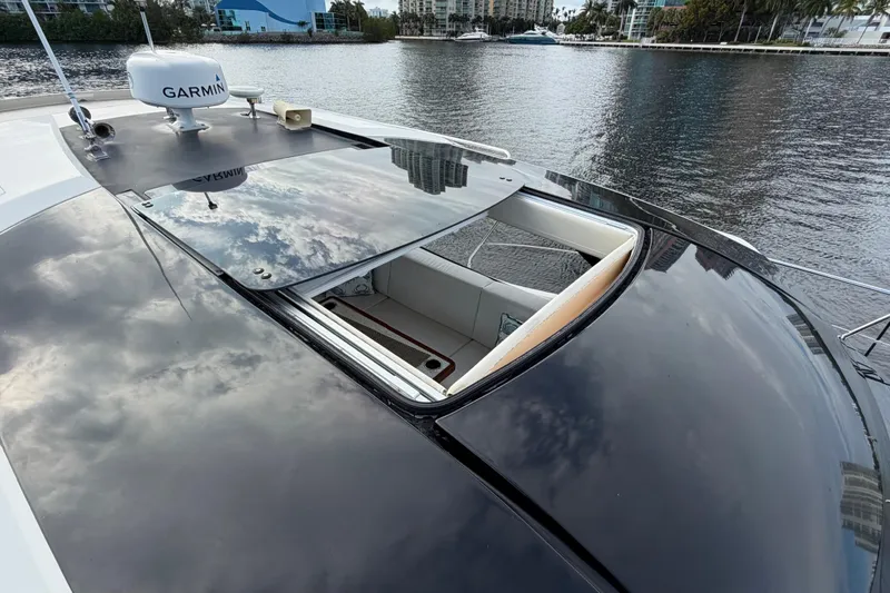 Slide: The Image of 2019 Carver C34 yacht with open sunroof, reflecting cloudy sky on water. - 18