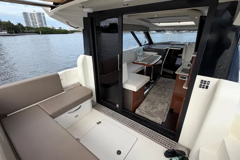 Slide: The Image of 2019 Carver C34 yacht interior with seating, table, and waterfront view. - 21