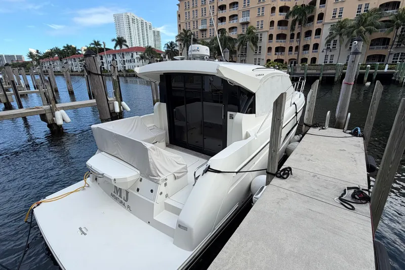 Slide: The Image of 2019 Carver C34 yacht docked at marina with waterfront buildings. - 23
