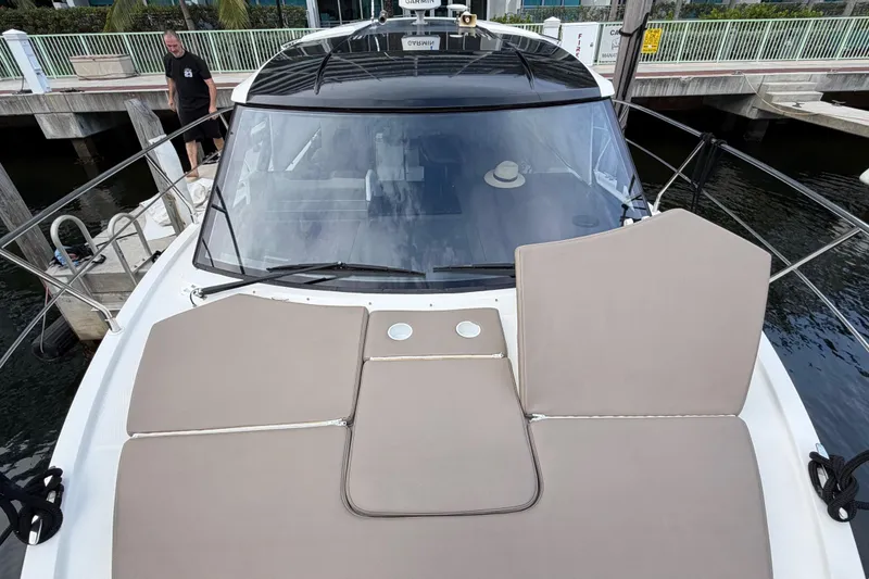 Slide: The Image of 2019 Carver C34 yacht with beige sunbathing cushions docked at marina. - 29