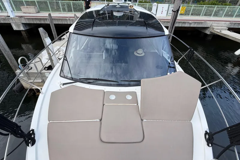 Slide: The Image of 2019 Carver C34 yacht with beige sunbathing cushions docked at marina. - 36