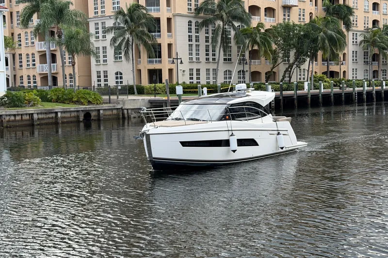 Slide: The Image of 2019 Carver C34 yacht cruising near waterfront apartments with palm trees. - 37