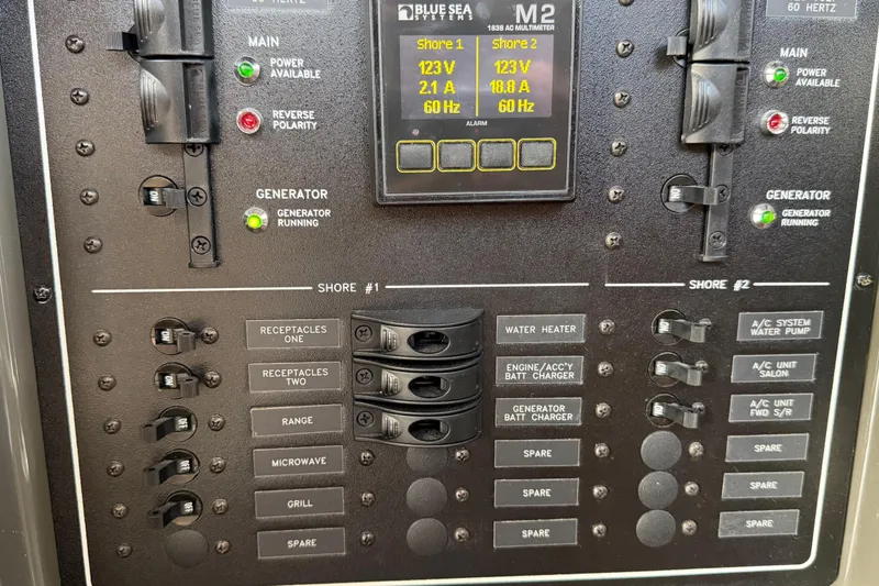 Slide: The Image of Electrical panel of a 2019 Carver C34 boat, featuring generator and shore power controls. - 39