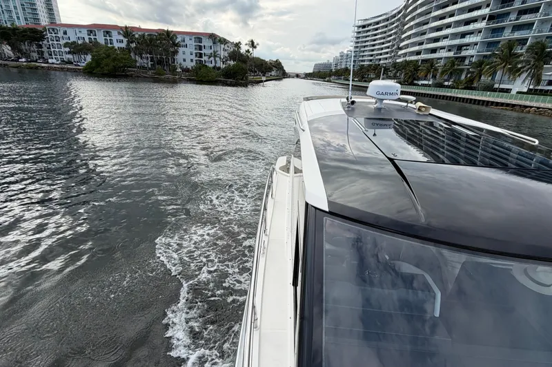 Slide: The Image of 2019 Carver C34 yacht cruising through a scenic waterway with modern buildings. - 6