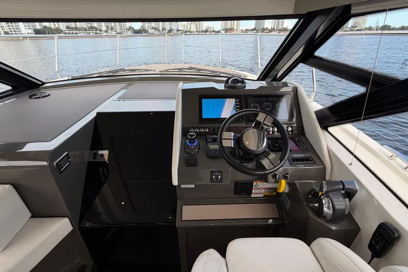 Slide: The Image of 2019 Carver C34 yacht helm with modern controls and navigation system, overlooking serene waters. - 8