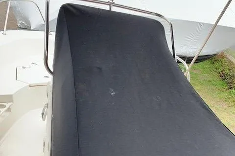 Slide: The Image of 2023 Boston Whaler 170 Montauk boat with black cover, partially visible in outdoor setting. - 14