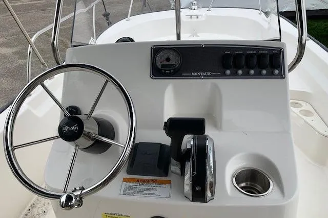 Slide: The Image of 2023 Boston Whaler 170 Montauk boat console with steering wheel and controls. - 15